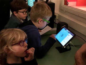 Photograph of group of children interacting with tablet